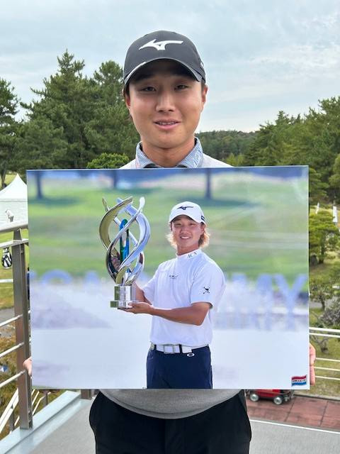 関西記者クラブ・ゴルフ分科会から贈られた写真パネルを手にする平田憲聖