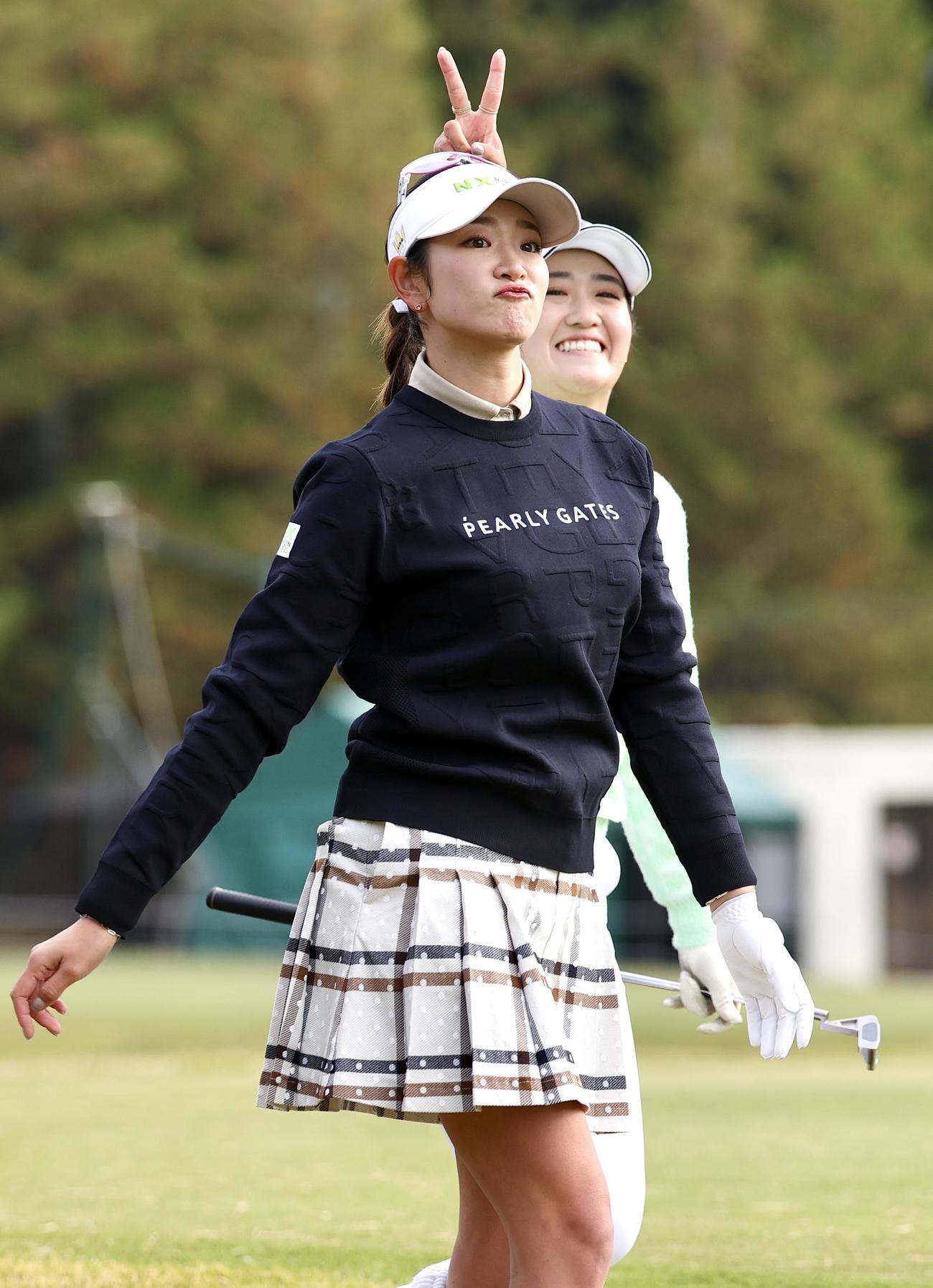 2番、ティーショットを放ち原英莉花（手前）の頭上でピースする稲見萌寧（撮影・宮地輝）