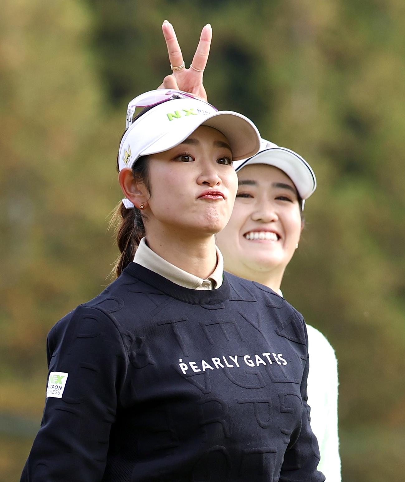 2番、ティーショットを放ち原英莉花（手前）の頭上でピースする稲見萌寧（撮影・宮地輝）