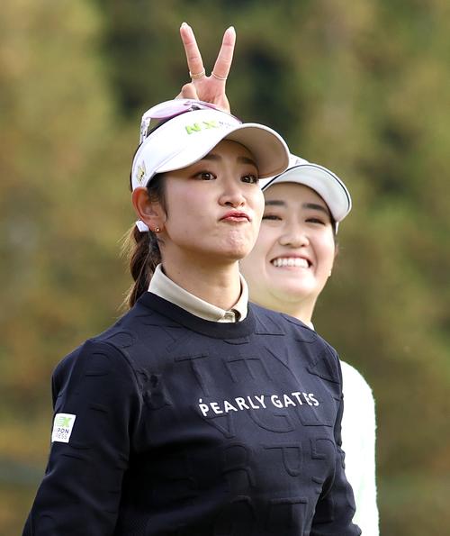 2番、ティーショットを放ち原英莉花（手前）の頭上でピースする稲見萌寧（撮影・宮地輝）