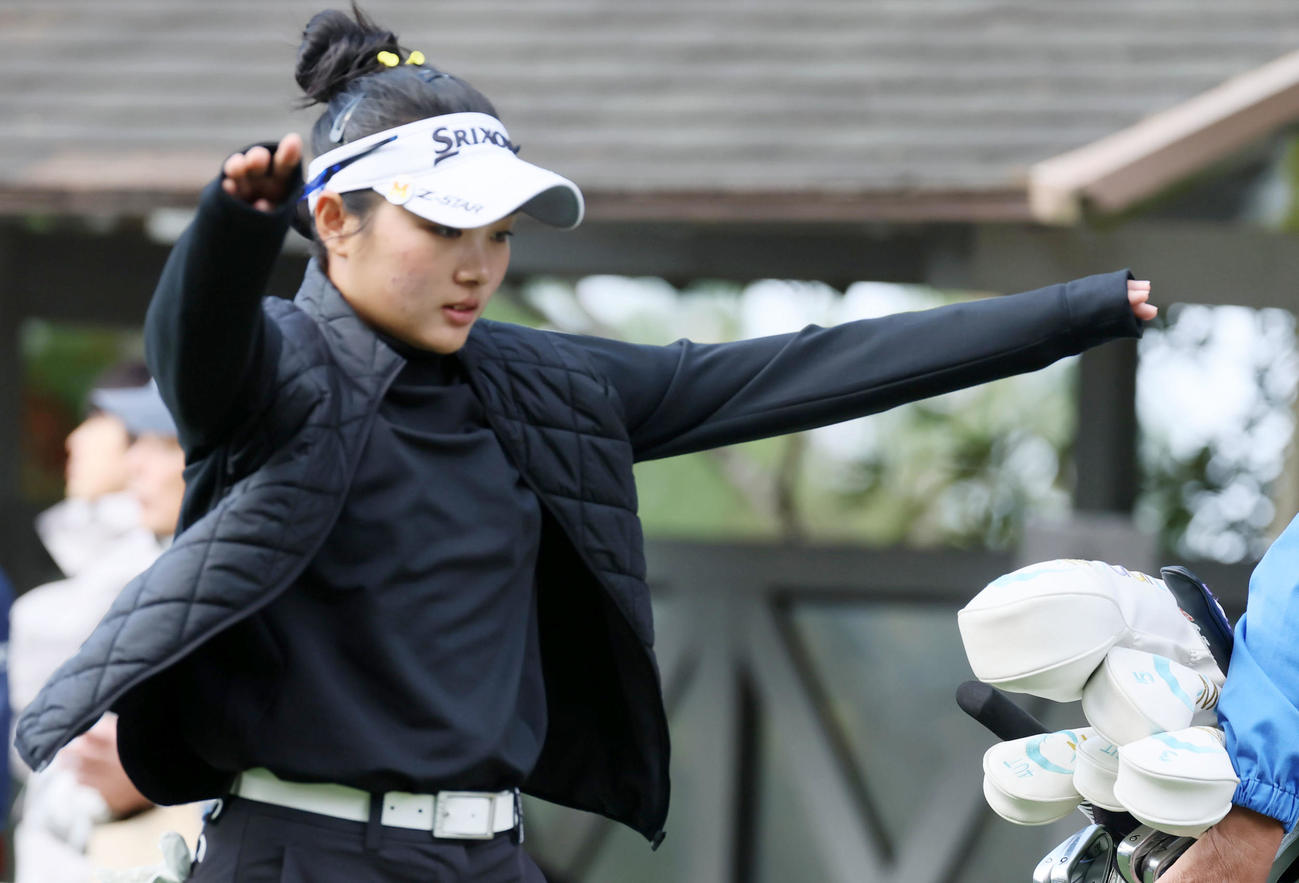 10番、ティーショットを打ち終え両手を広げて上着を羽織るアマチュアの吉崎マーナ（撮影・加藤哉）