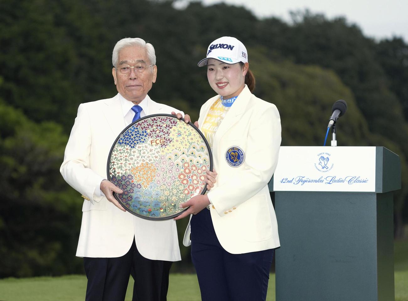 2024年4月の日本女子ゴルフツアー、フジサンケイ・レディースで優勝した竹田麗央（右）と写真に納まる大会会長の日枝久フジサンケイグループ代表（当時）＝静岡県の川奈ホテルGC富士(共同)