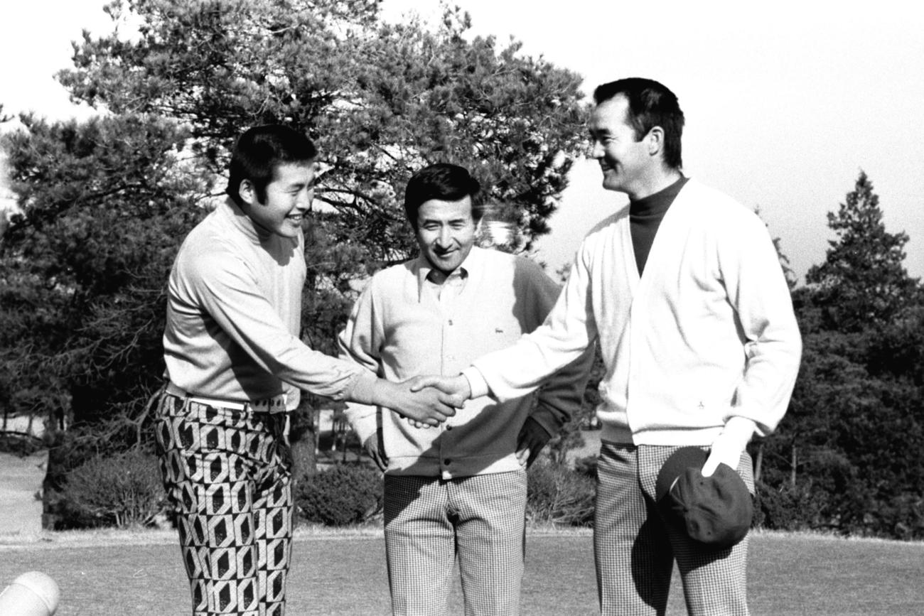 がっちり握手をする尾崎将司さんと長嶋茂雄さん（右）。中央は野球評論家の佐々木信也さん（1972年12月撮影）