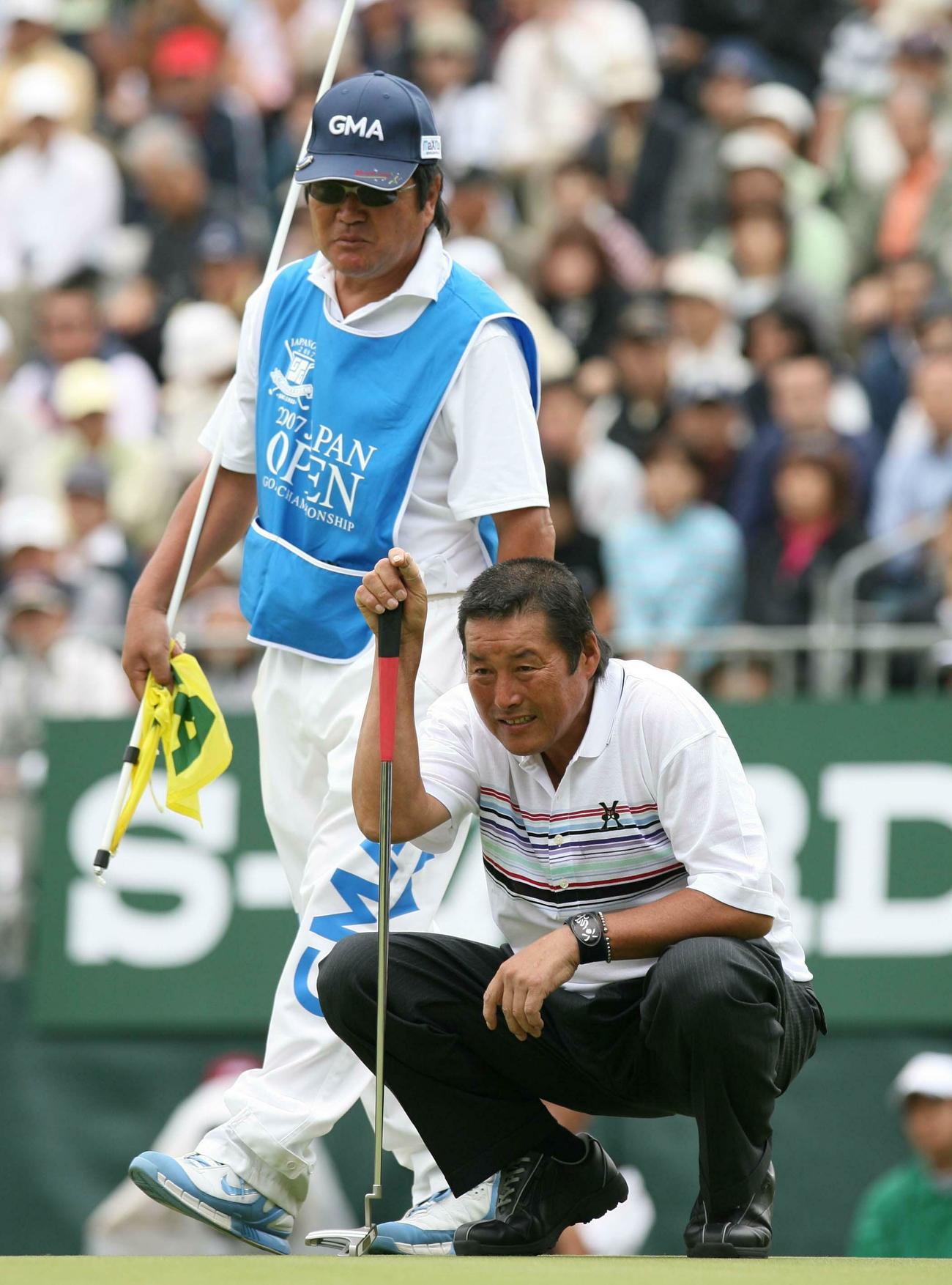 ラインを読む尾崎将司。左は佐野木計至キャディー（2007年10月撮影）