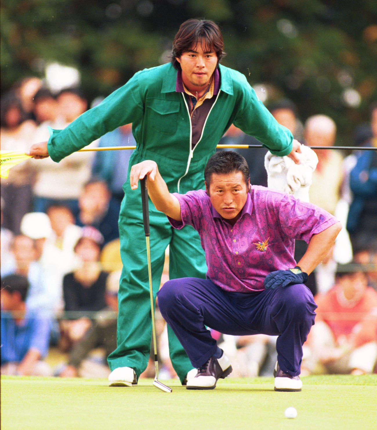 ラインを読む尾崎将司さんとキャディーを務める長男の智春さん（1994年11月撮影）