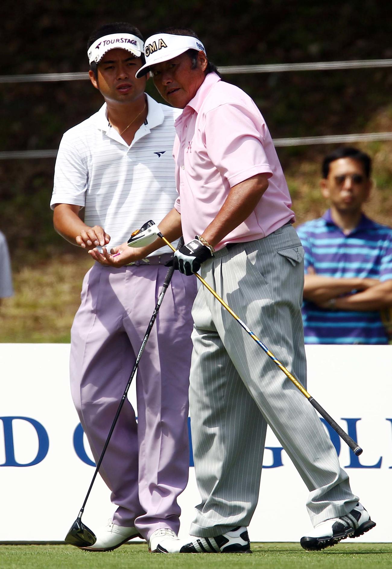 12年5月、尾崎将司さん（右）のティーを拾う池田勇太。スリータックの競演となった