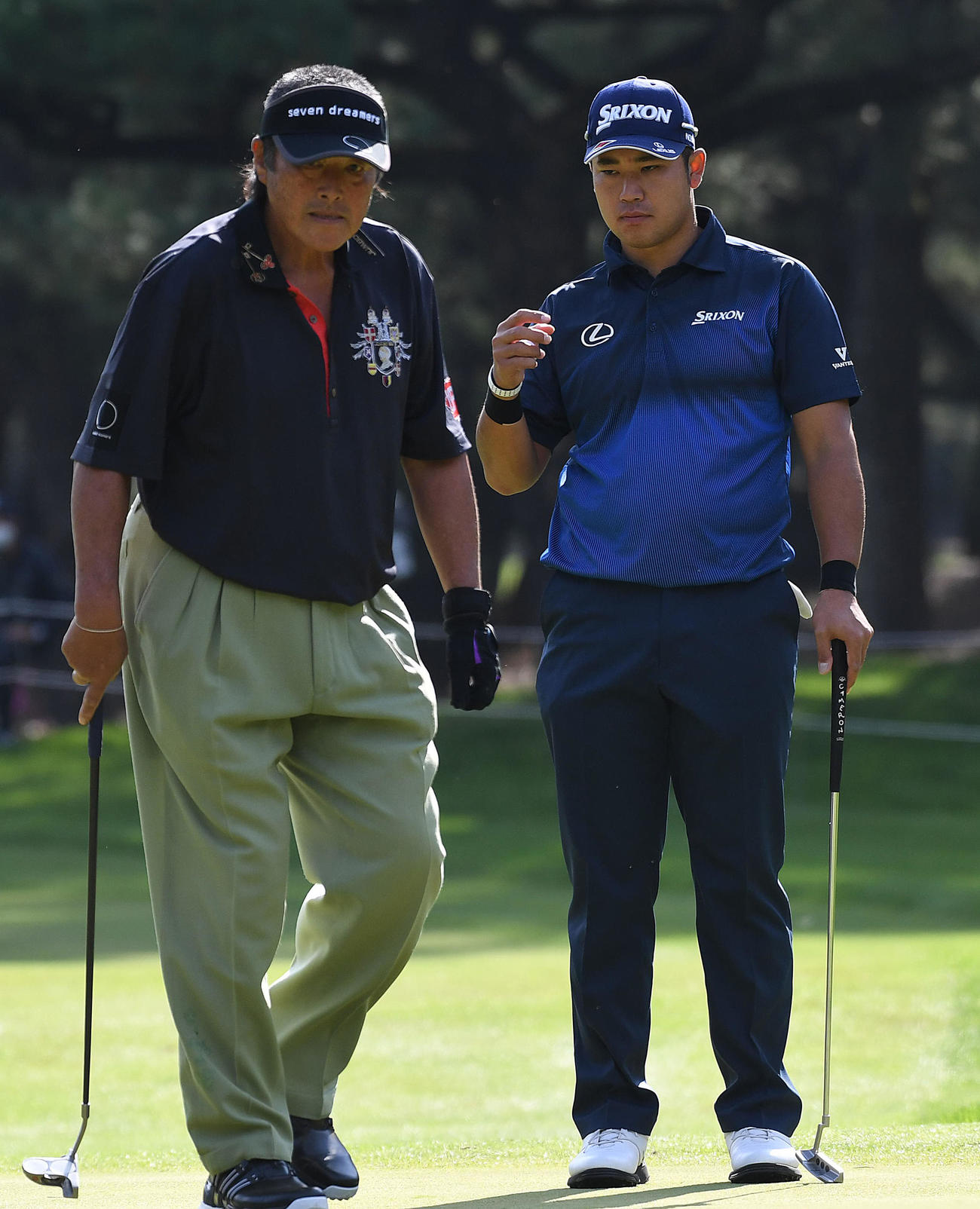 尾崎将司さん（左）のパットを見つめる松山（2017年11月撮影）