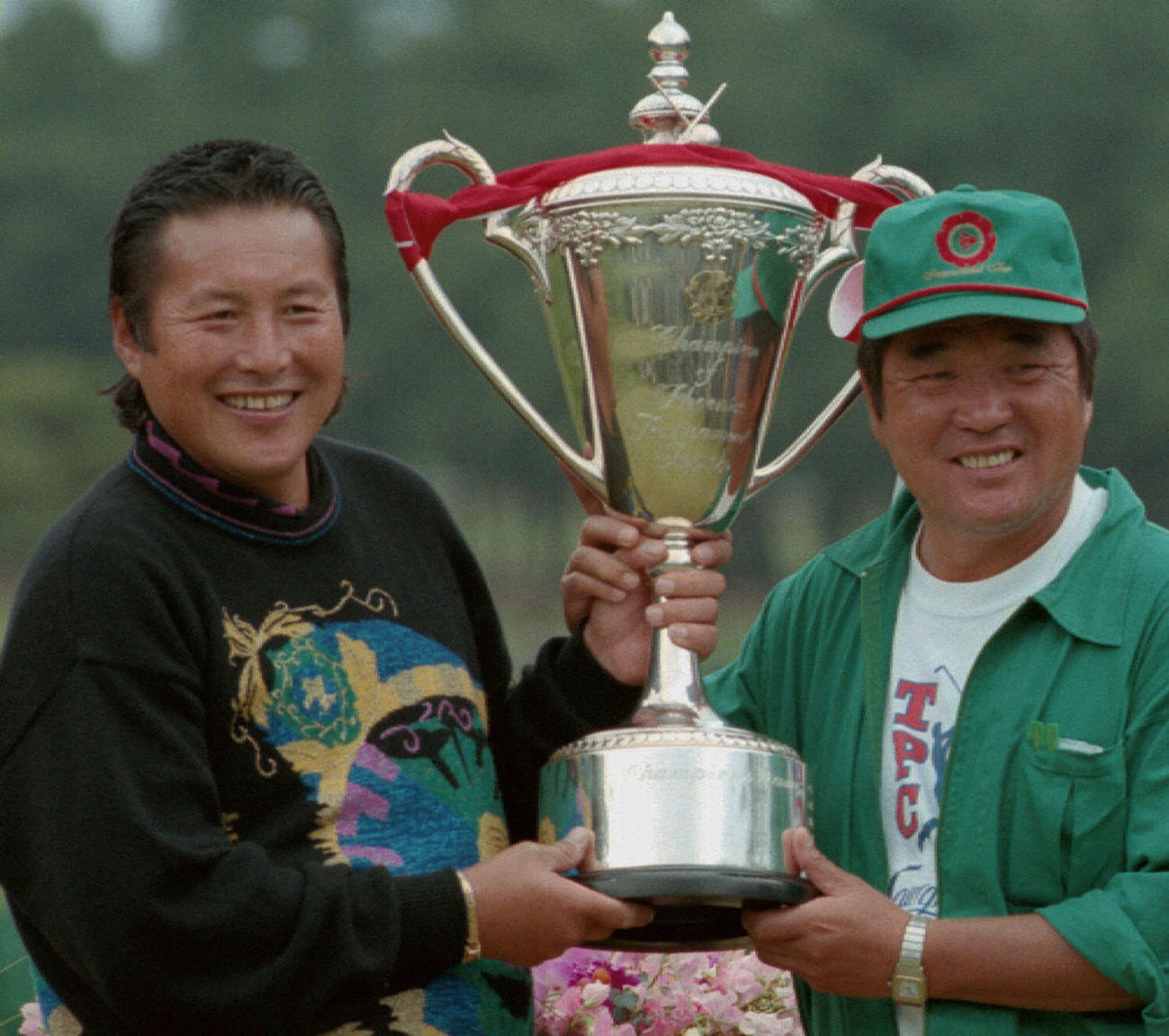 フェニックスゴルフ最終日　プロ通算100勝目の優勝カップを手に喜ぶ尾崎将司（左）とキャディーの佐野木計至さん　1996年11月17日　共同お買上