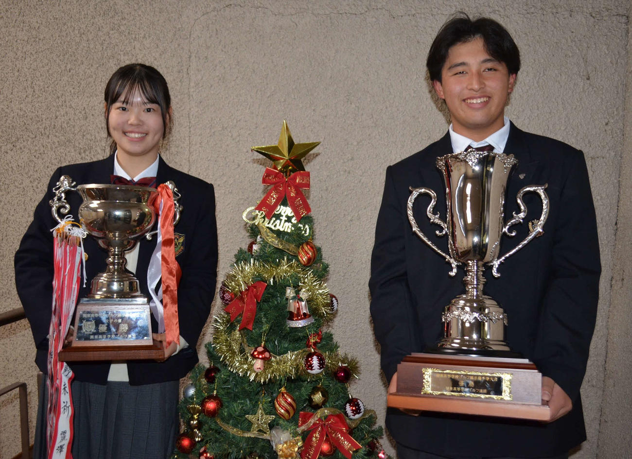 クリスマスツリーを間に笑顔を見せる優勝した女子の臼田藍（左）と男子の沖田雫