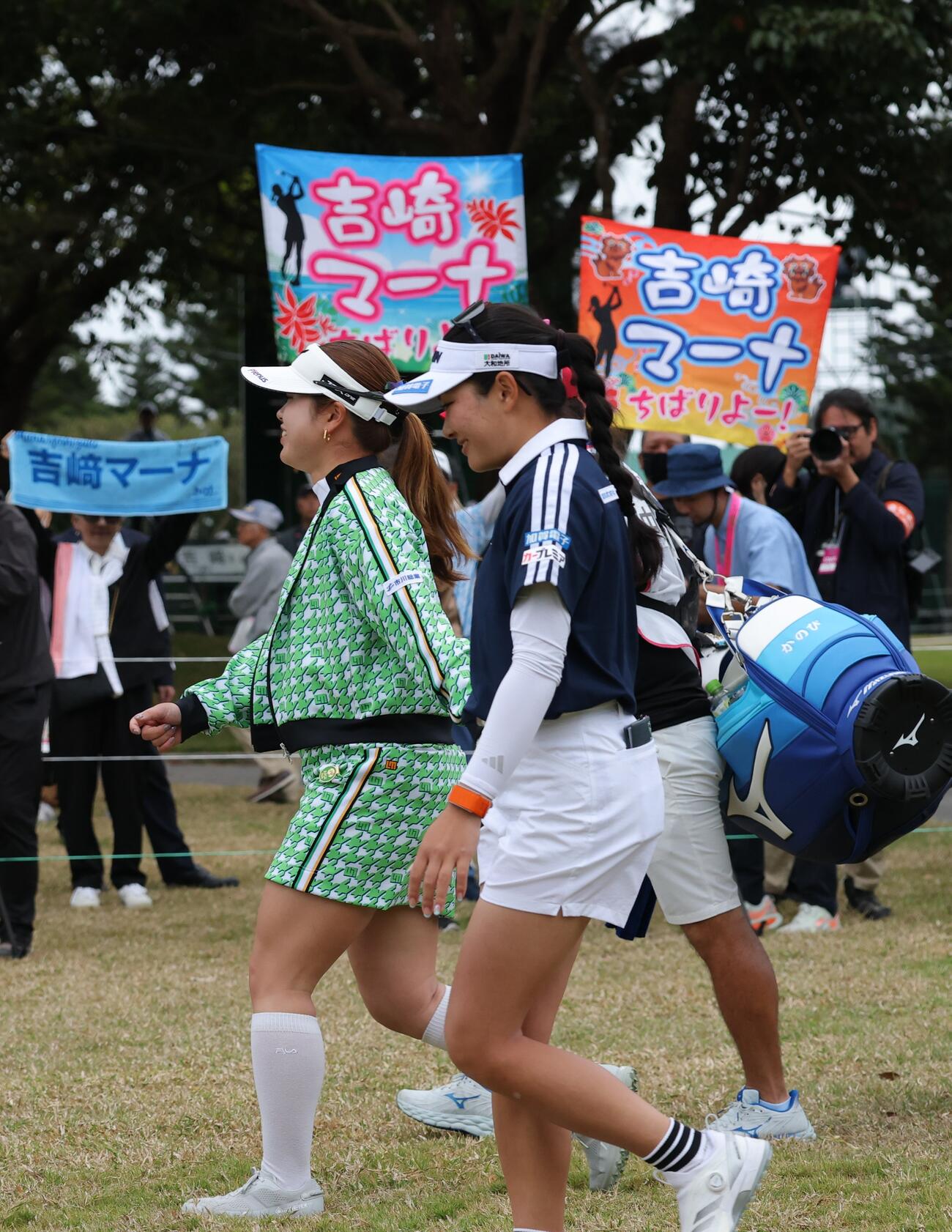 1番、吉崎（手前）はティーショットを放ちファンを横にセカンド地点へ向かう（撮影・上山淳一）