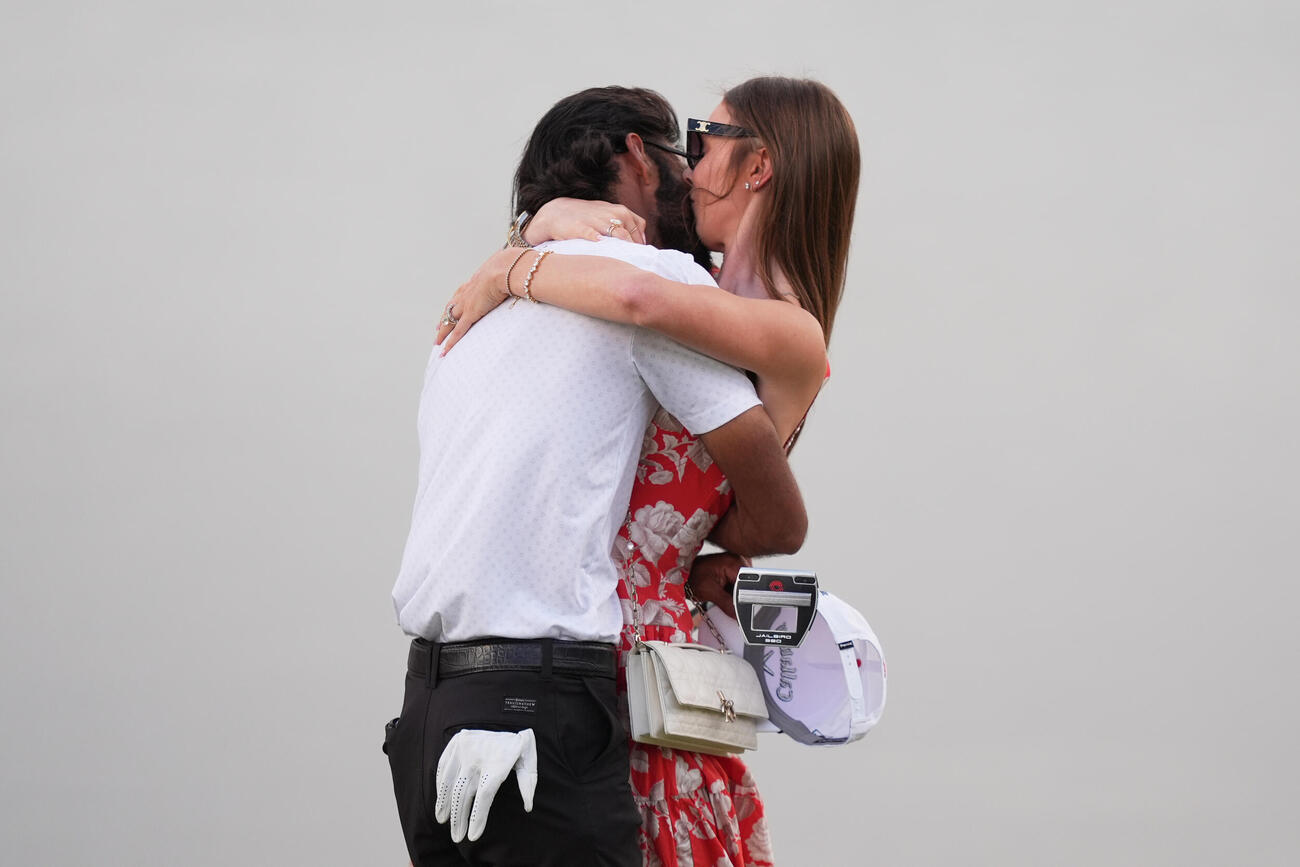 妻プレズリー・シュルツとキスをする優勝したアックシェイ・バティア（左、AP）