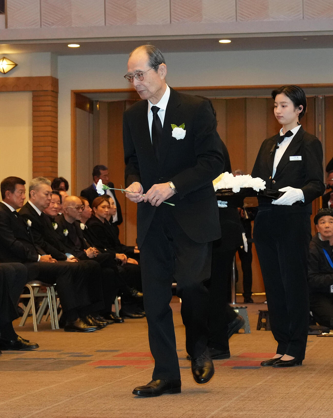 献花する王氏（撮影・足立雅史）