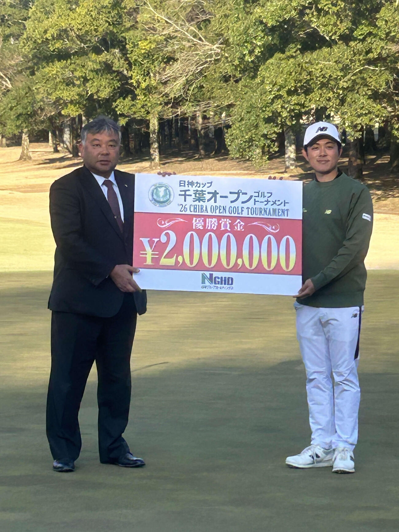 特別協賛社の日神グループホールディングス神山隆志代表取締役社長から優勝賞金目録を受け取る山脇健斗（右）