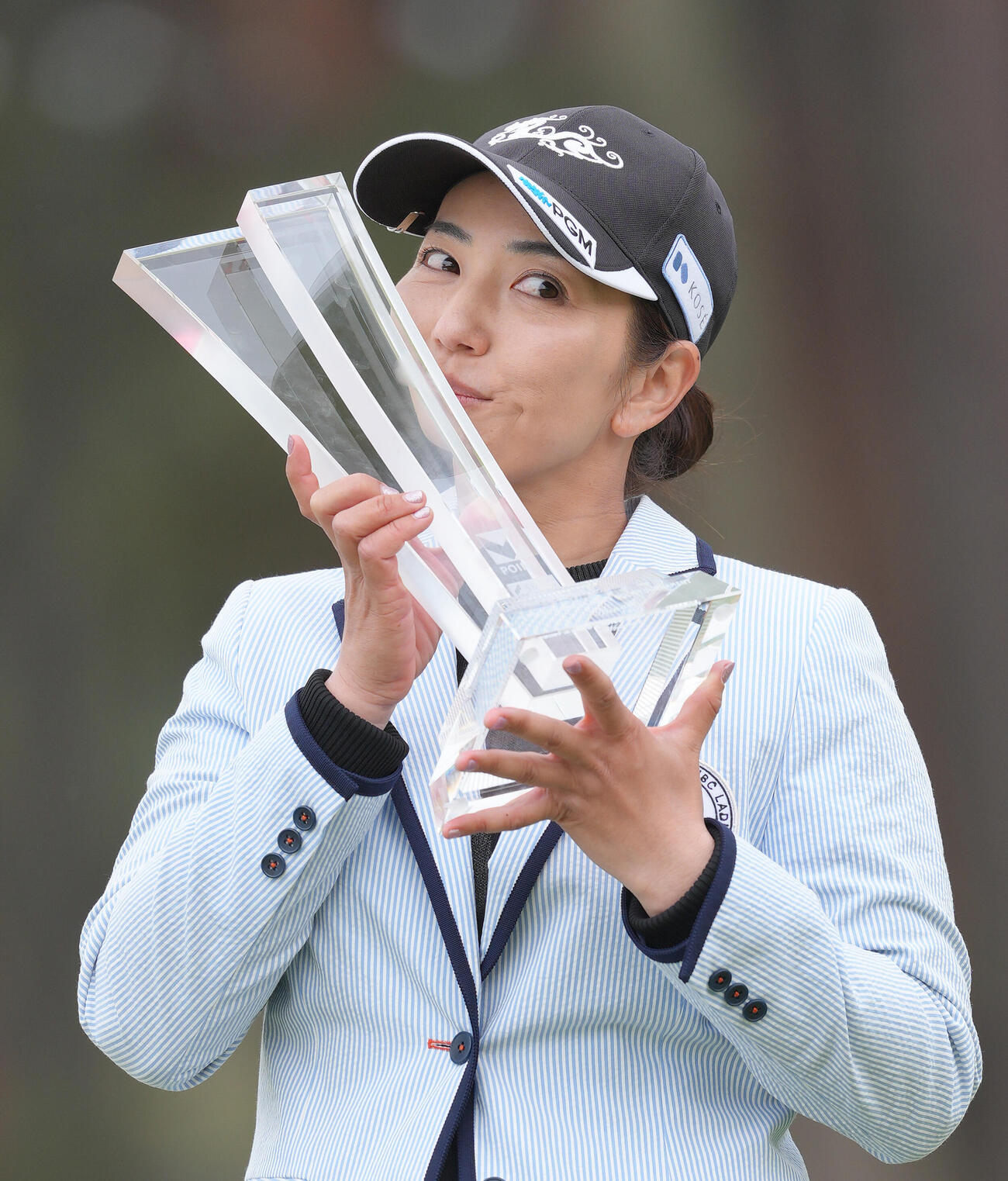 優勝トロフィーにキスする笠（撮影・足立雅史）
