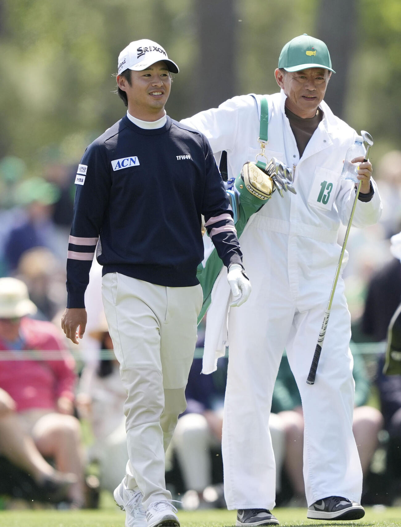 「パー3コンテスト」に参加し、キャディーを務めた父誠之さん（右）と和やかにプレーする片岡尚之（共同）