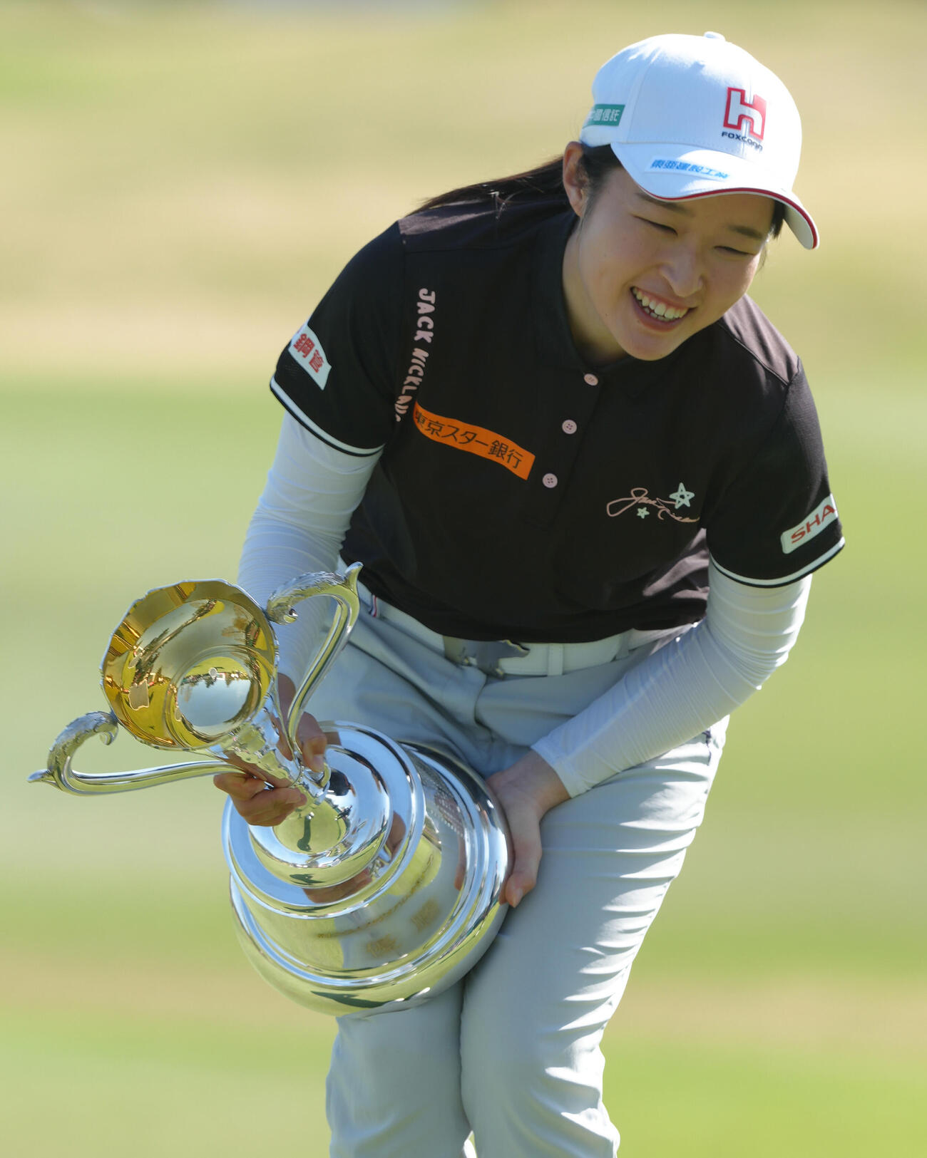 優勝カップを重たそうに持ち上げるウー・チャイェン（撮影・足立雅史）