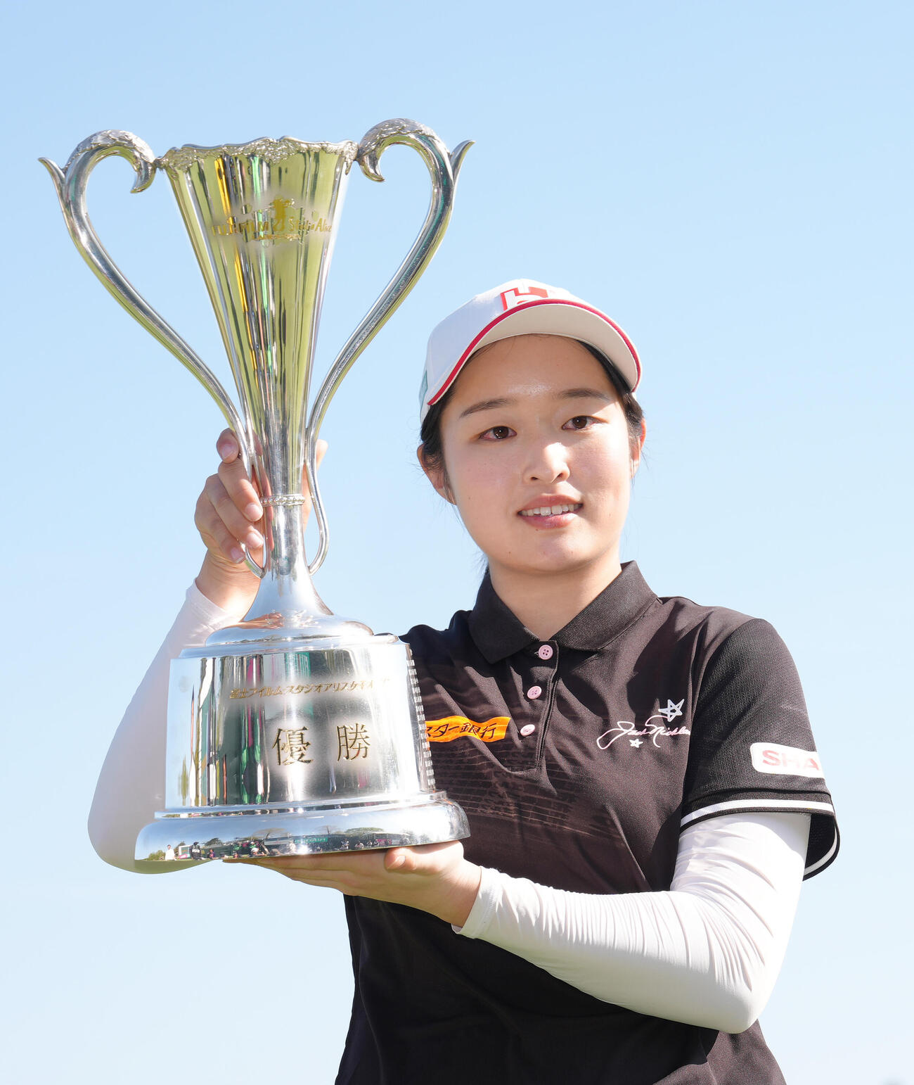 優勝カップを掲げるウー・チャイェン（撮影・足立雅史）