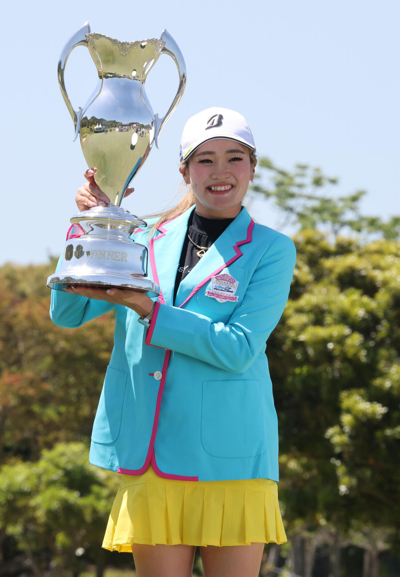 優勝カップを掲げ笑顔を見せる桑木志帆（撮影・梅根麻紀）