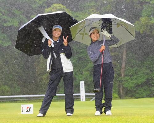 激しい雨の中、笑顔を見せる堀琴音（左）と青木瀬令奈（撮影・足立雅史）