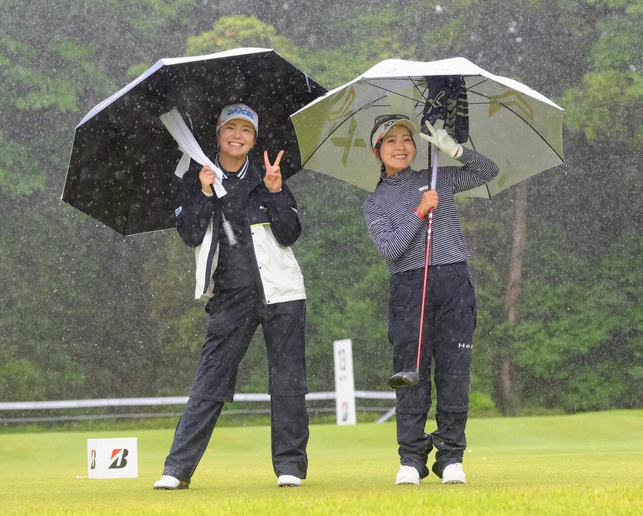 激しい雨の中、笑顔を見せる堀琴音（左）と青木瀬令奈（撮影・足立雅史）