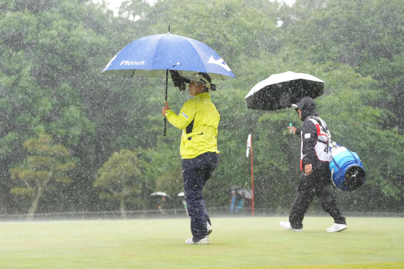 降雨によるコースコンディション不良のため競技が一時中断し、クラブハウスへと戻る仲村果乃（左）（撮影・足立雅史）