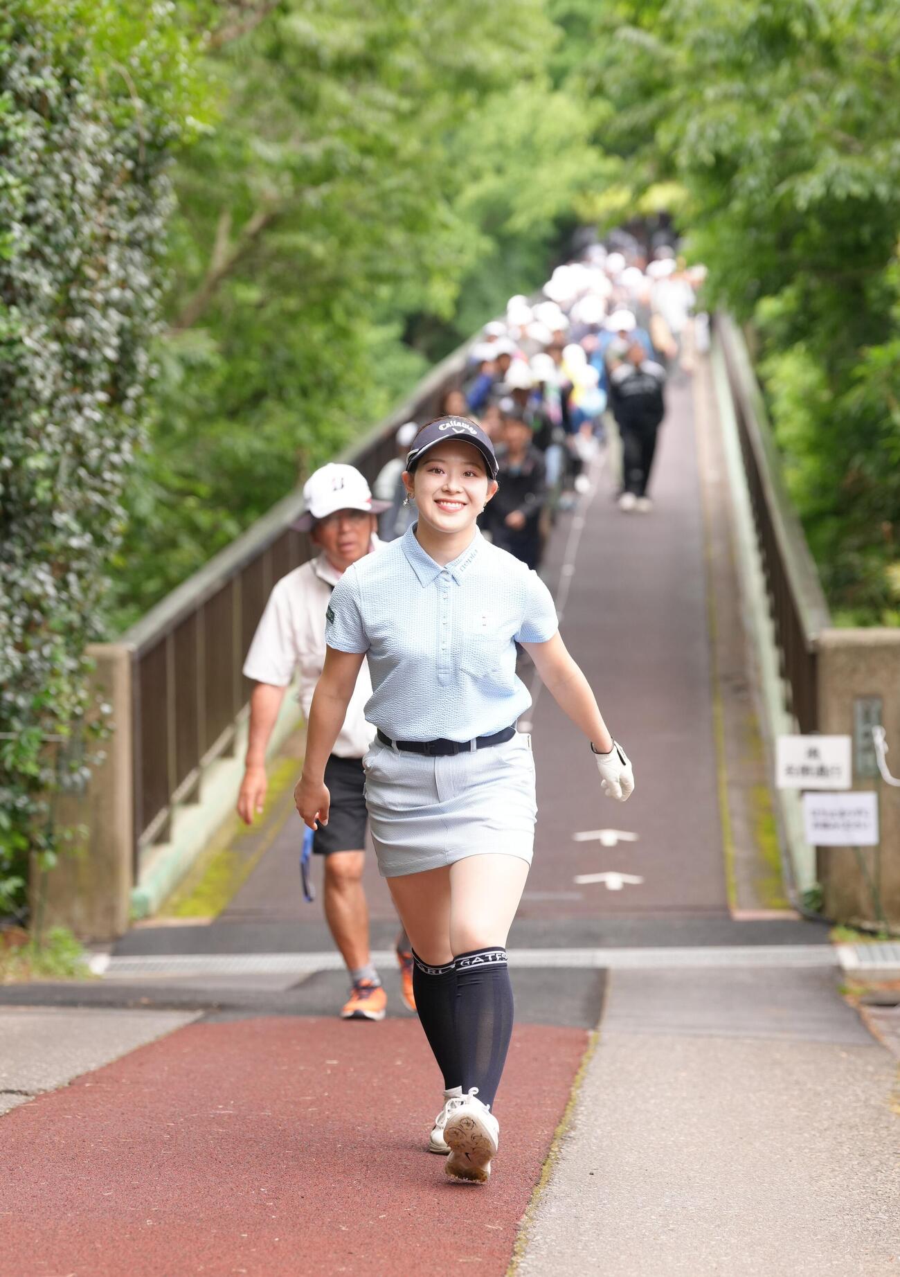 笑顔で橋を渡る吉田鈴（撮影・足立雅史）