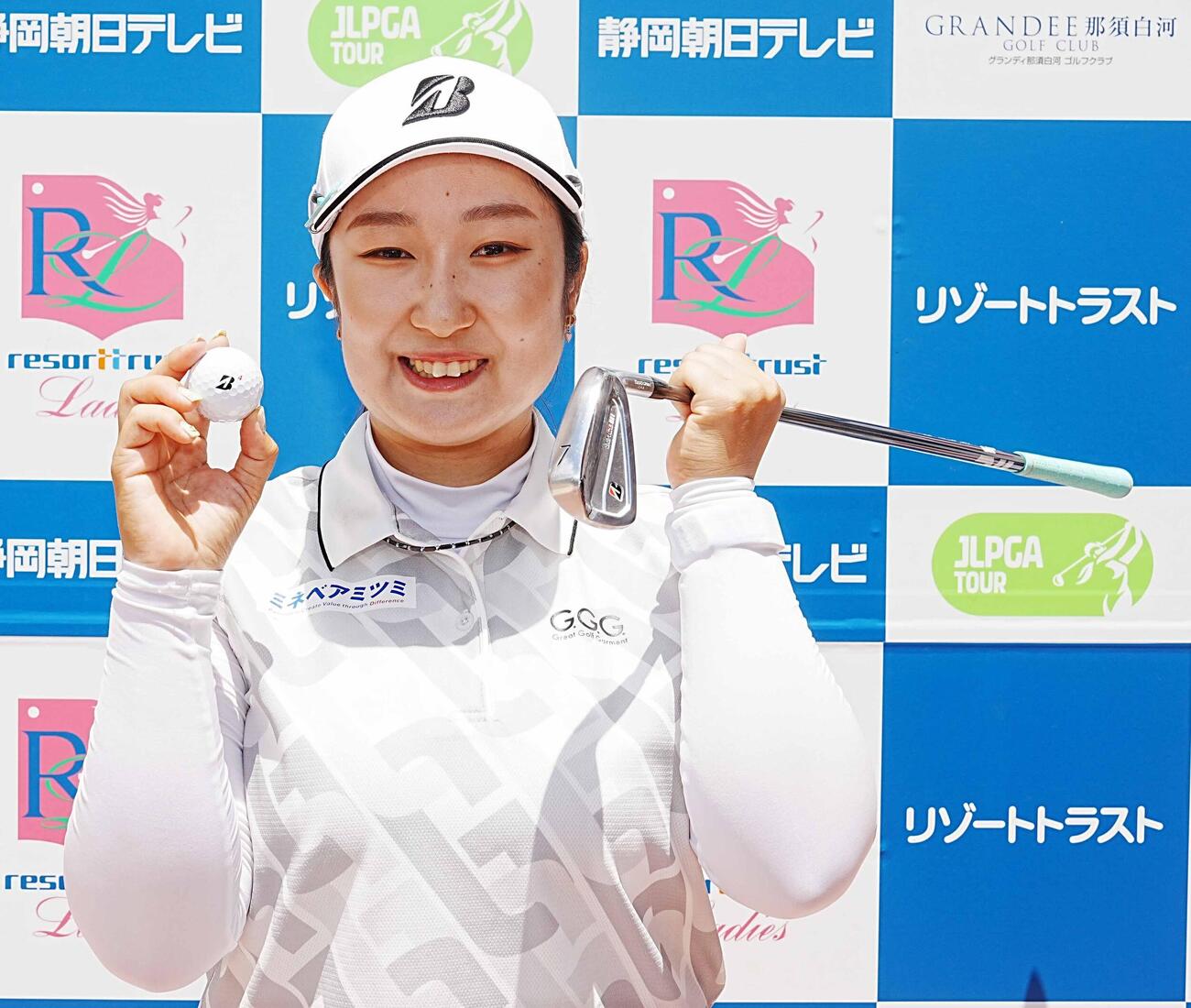 リゾートトラストレディース第2日　8番ショートでホールインワンを達成した阿部未悠はプレー終了後に7番アイアンとボールを手に笑顔を見せる（撮影・小沢裕）
