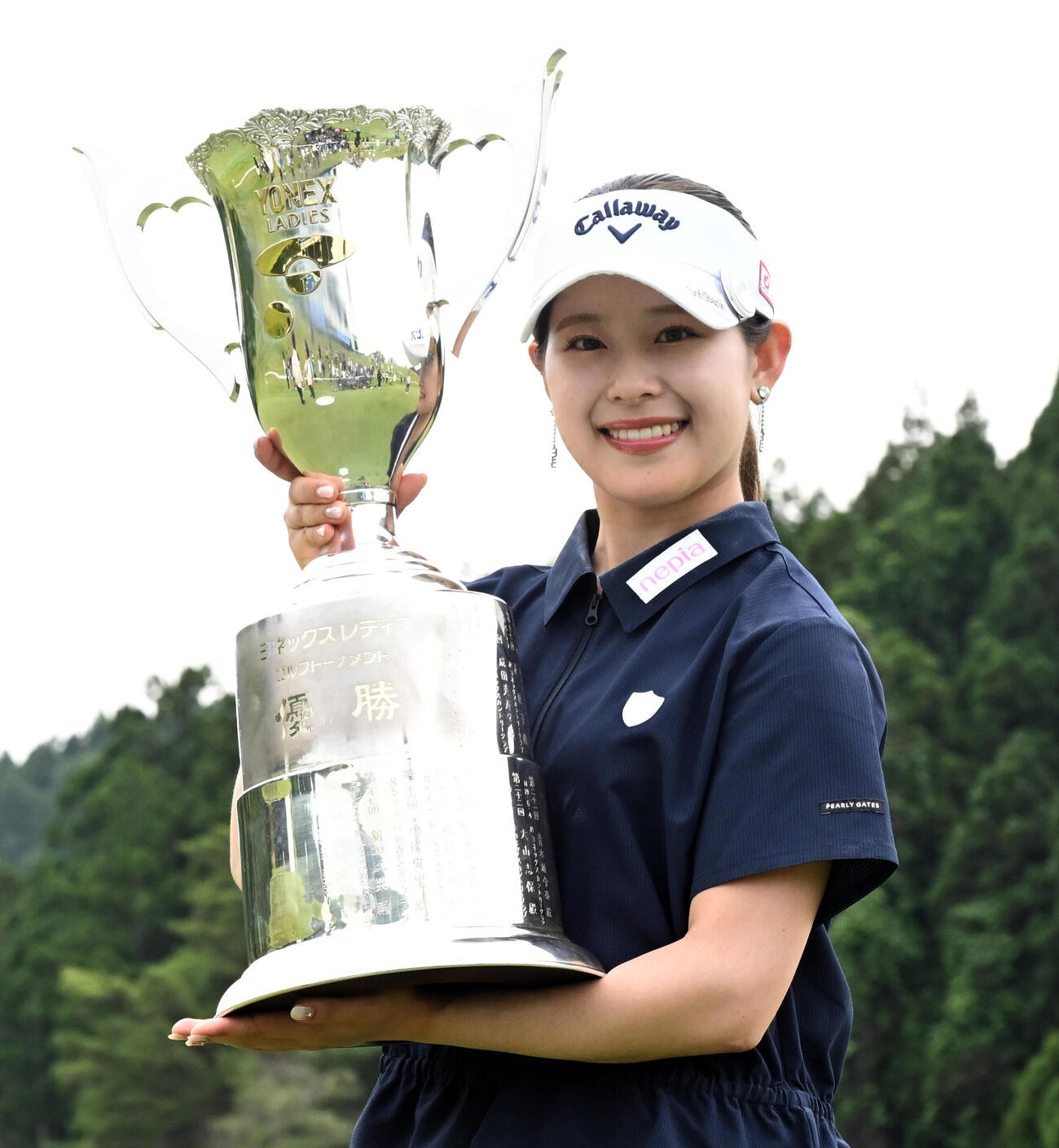 通算8アンダーで初優勝し、トロフィーを手に笑顔を見せる吉田鈴（撮影・千葉一成）