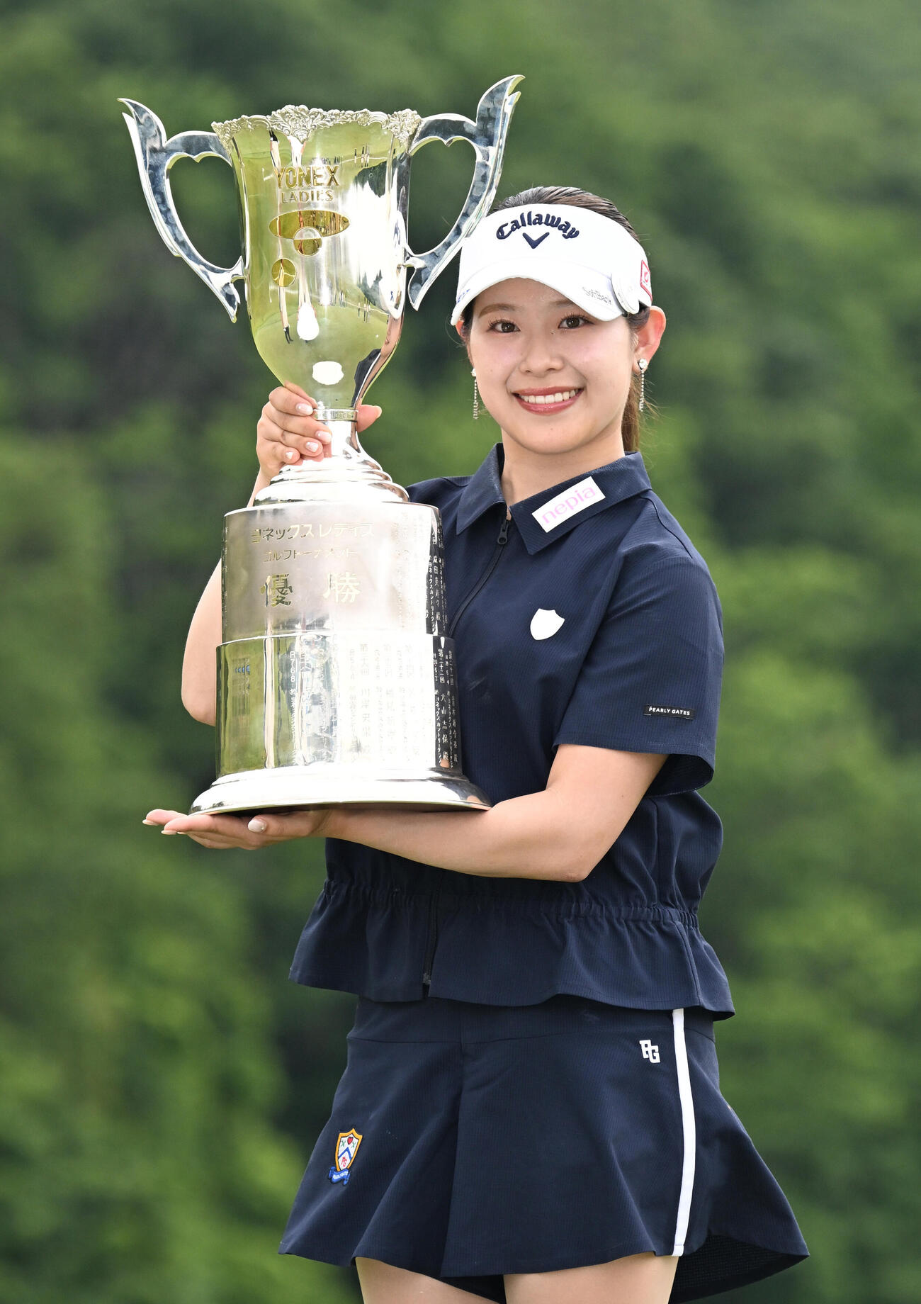 通算8アンダーで初優勝し、トロフィーを手に笑顔を見せる吉田鈴（撮影・千葉一成）