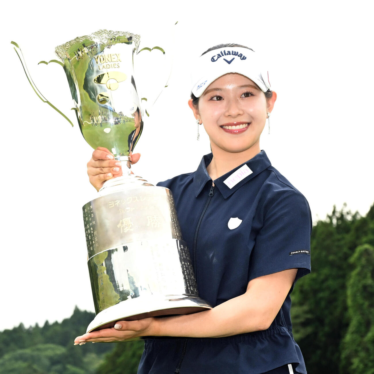 通算8アンダーで初優勝し、トロフィーを手に笑顔を見せる吉田鈴（撮影・千葉一成）＝2026年6月7日