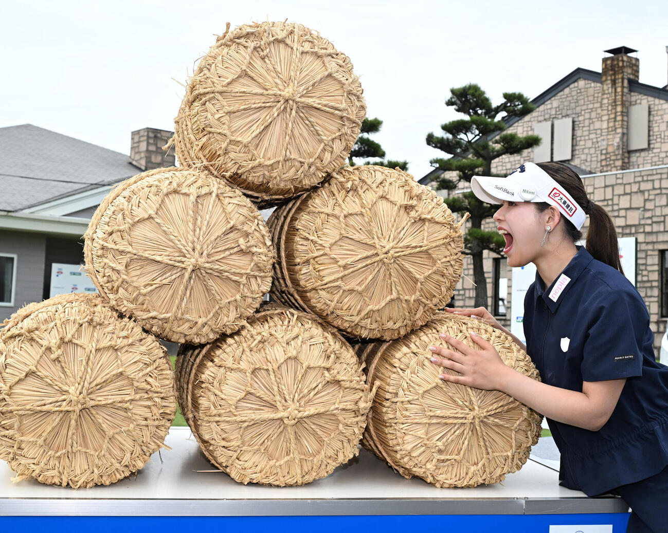 通算8アンダーで初優勝し、副賞の米俵にかぶりつくポーズをとる吉田鈴（撮影・千葉一成）＝2026年6月7日