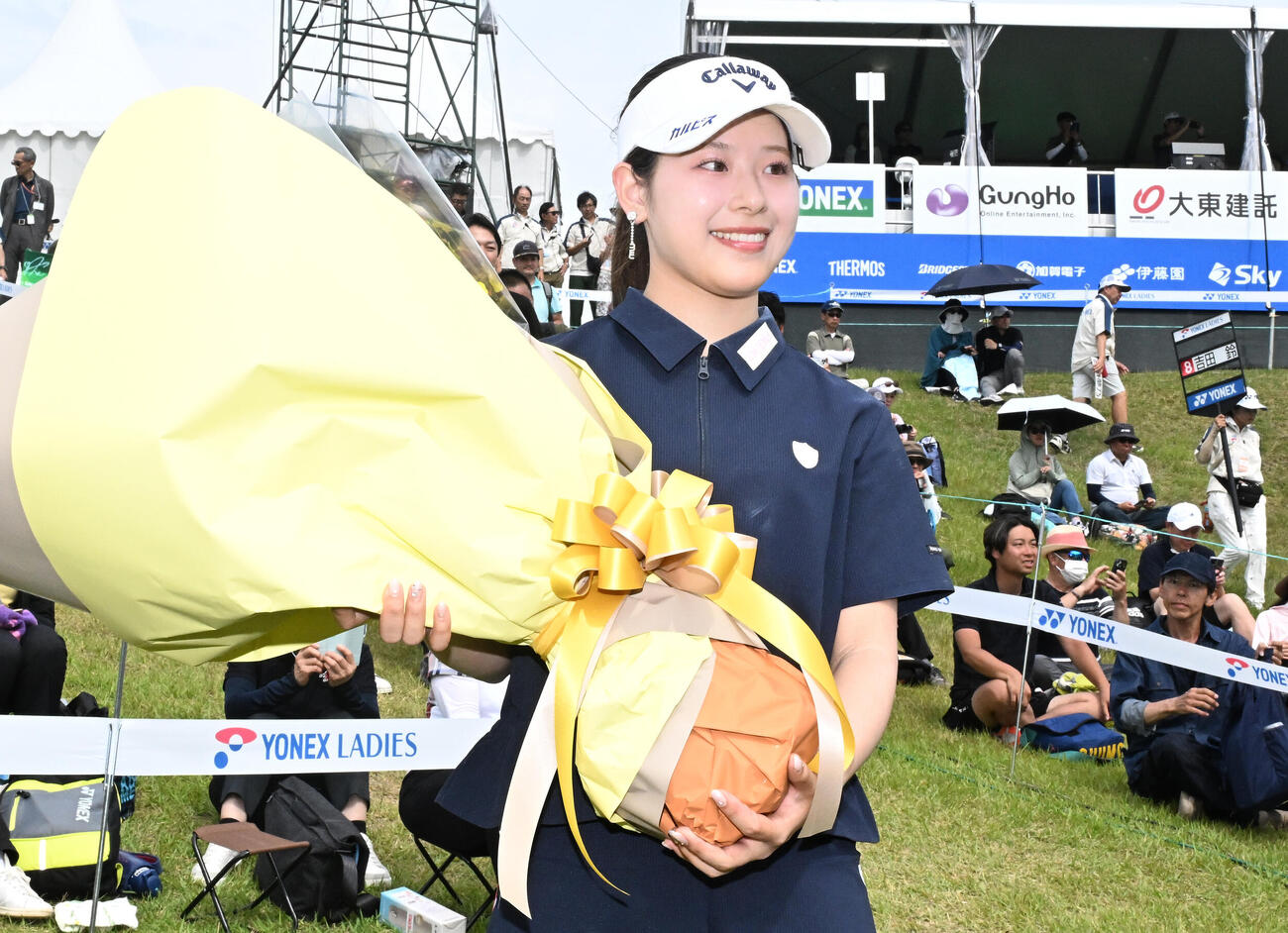 通算8アンダーで初優勝を決め、贈られた花束を手に笑顔を見せる（撮影・千葉一成）＝2026年6月7日