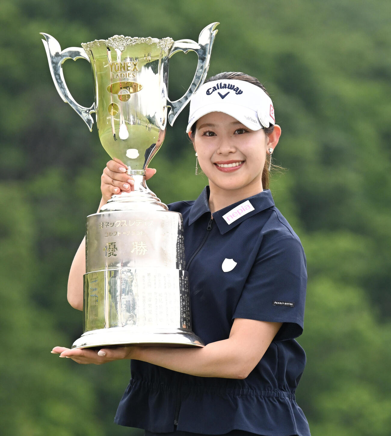 通算8アンダーで初優勝し、トロフィーを手に笑顔を見せる吉田鈴（撮影・千葉一成）