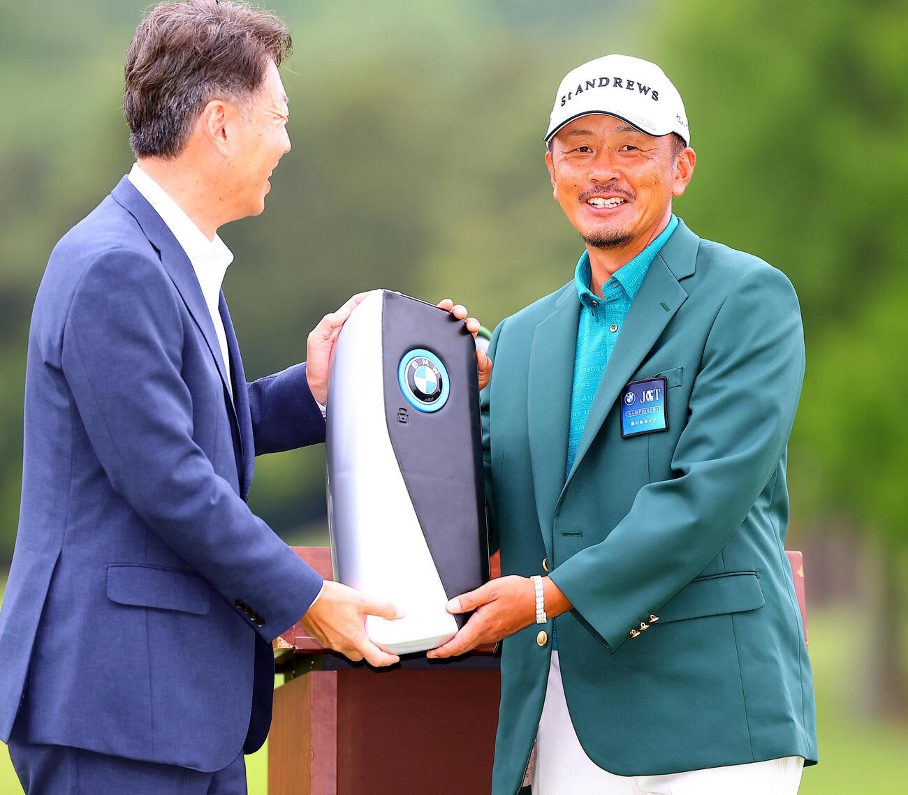 BMW日本ツアー選手権森ビル杯　優勝し、BMW上野金太郎社長（左）から副賞のX6のジャンボキーを贈られ笑顔をみせる岩田寛（撮影・野上伸悟）