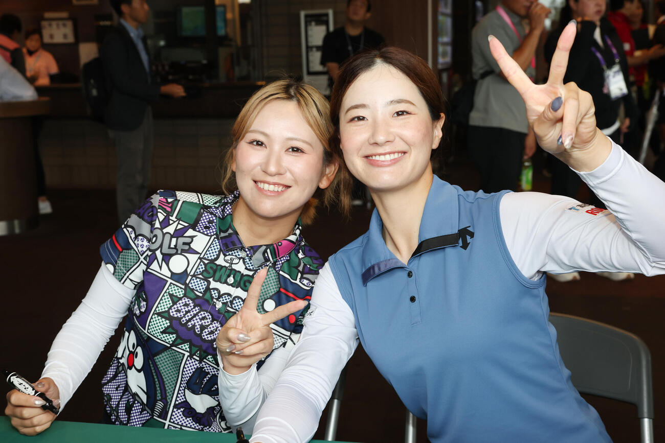 サイン会を行い笑顔でピースする平塚新夢（左）と青木香奈子（撮影・宮地輝）