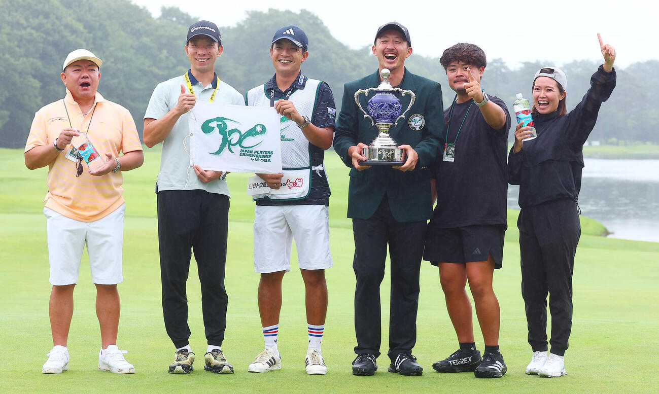 優勝し、真衣夫人（右端）ら関係者と喜ぶ岩崎亜久竜（右から3人目）（撮影・野上伸悟）