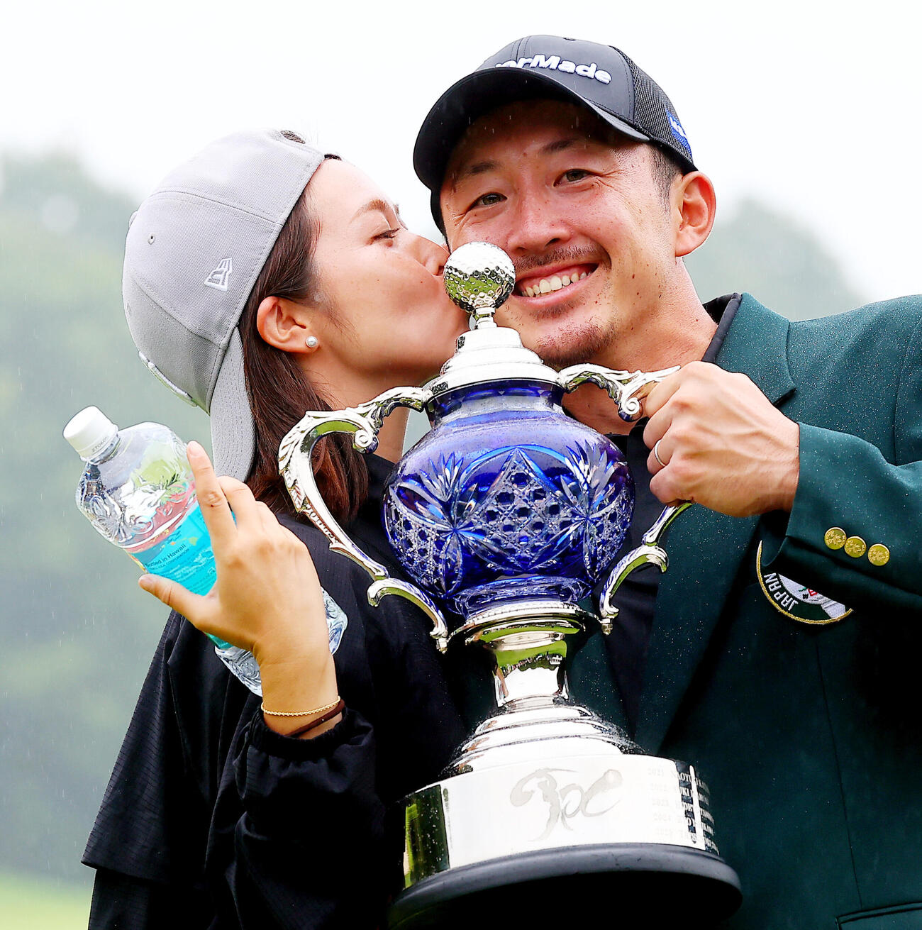 優勝し、真衣夫人（左）からキスで祝福される岩崎亜久竜（撮影・野上伸悟）