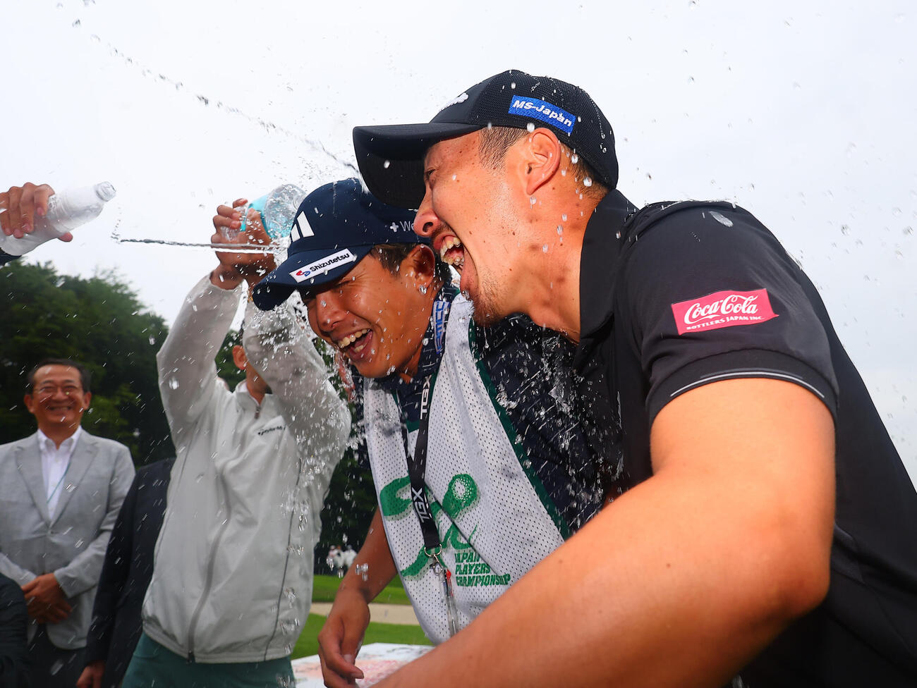 優勝しウォーターシャワーで祝福される岩崎亜久竜。左は湯本開史キャディー（撮影・野上伸悟）