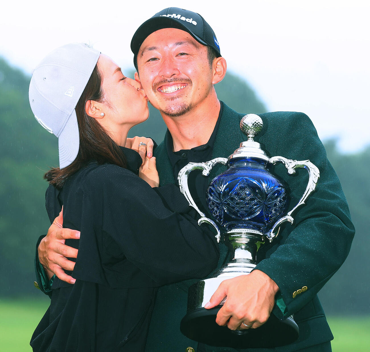 優勝し、真衣夫人（左）からキスで祝福される岩崎亜久竜（撮影・野上伸悟）