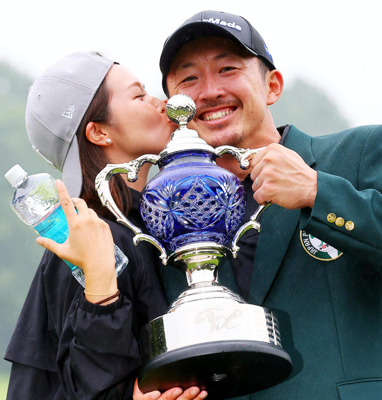 優勝し、真衣夫人（左）からキスで祝福される岩崎亜久竜（撮影・野上伸悟）