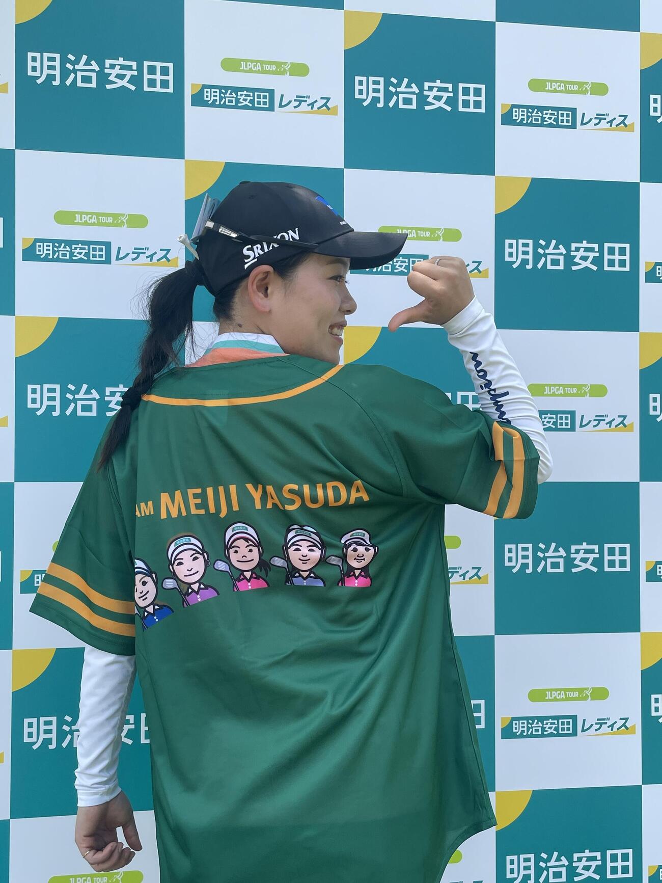 背中に所属5選手の似顔絵が描かれた明治安田ベースボールシャツを見せる勝みなみ