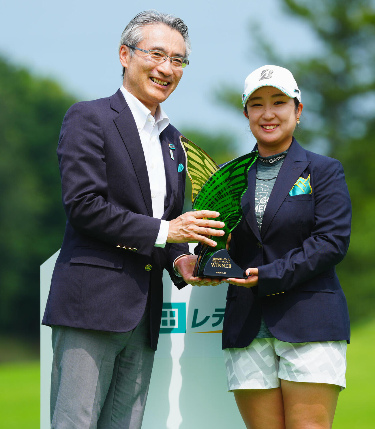 トロフィー贈呈で写真に納まる阿部未悠（右）と明治安田の永島英器社長（撮影・垰建太）