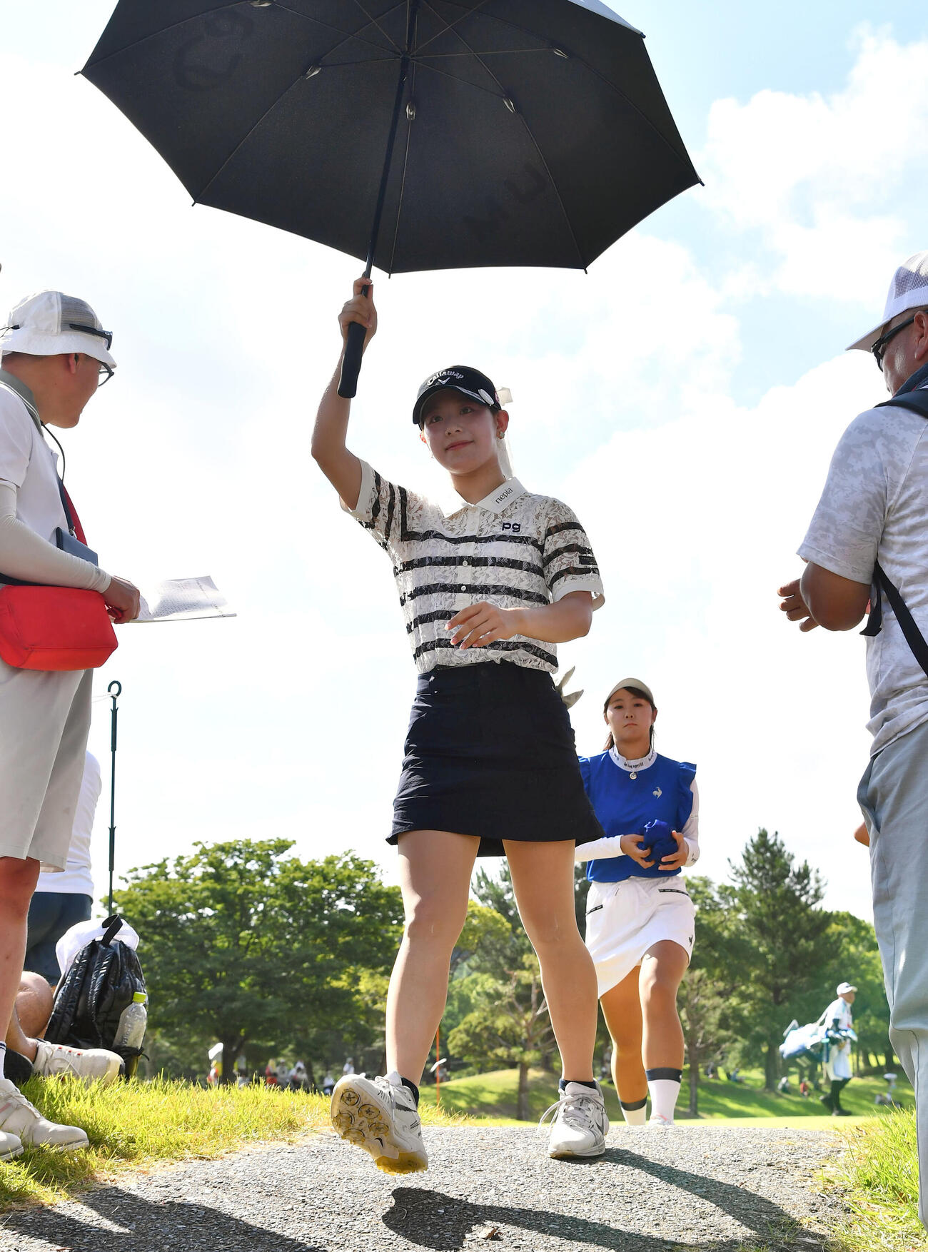 日傘をさして6番に移動する吉田鈴（撮影・岩下翔太）