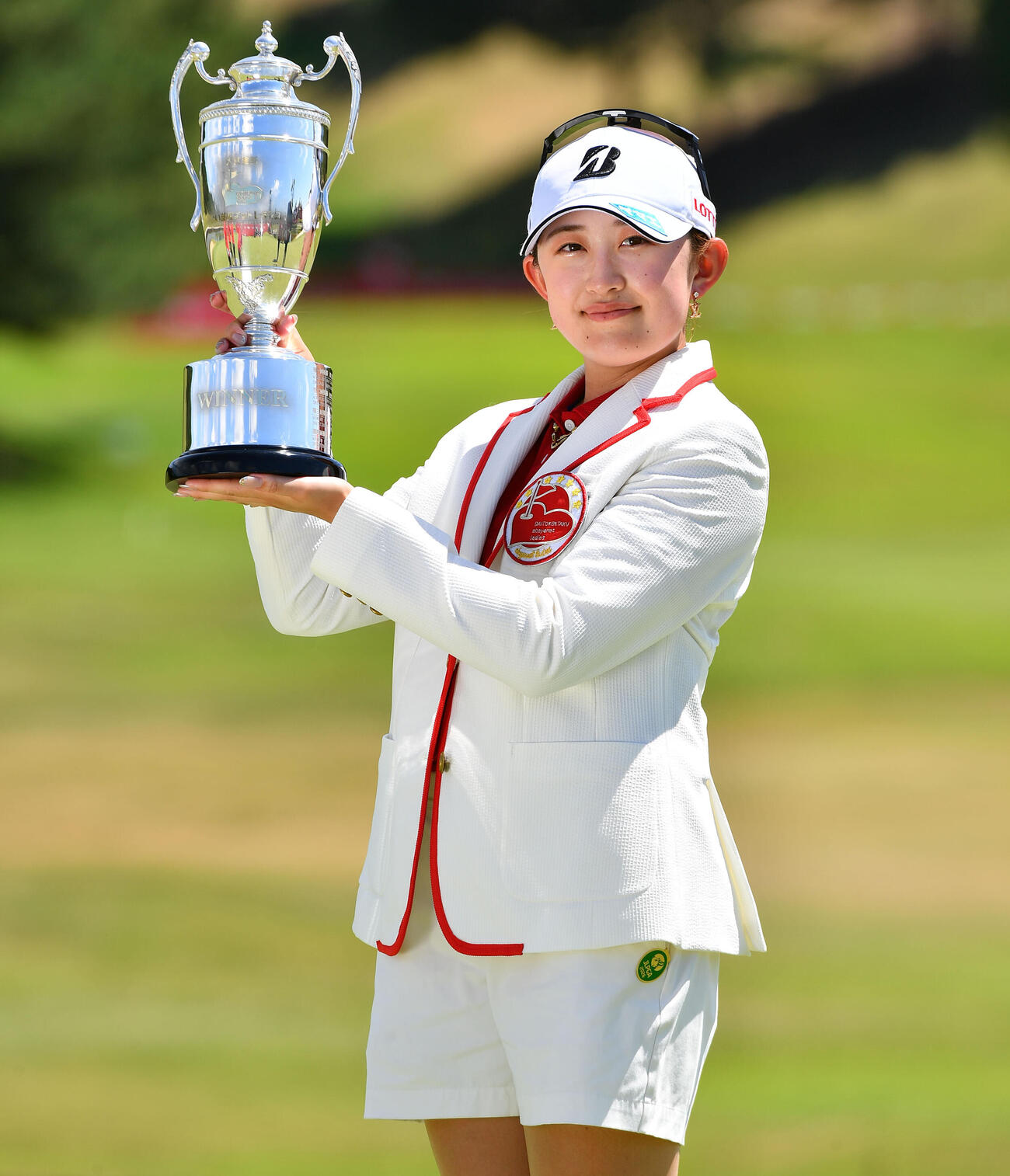 ツアー初優勝を決め、優勝カップを掲げる加藤麗奈（撮影・岩下翔太）