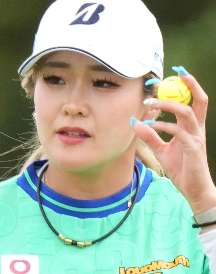 最終ラウンド、2番でバーディーパットを決め、拍手に応える桑木志帆。手元はカラフルなネイルで彩られている（共同）