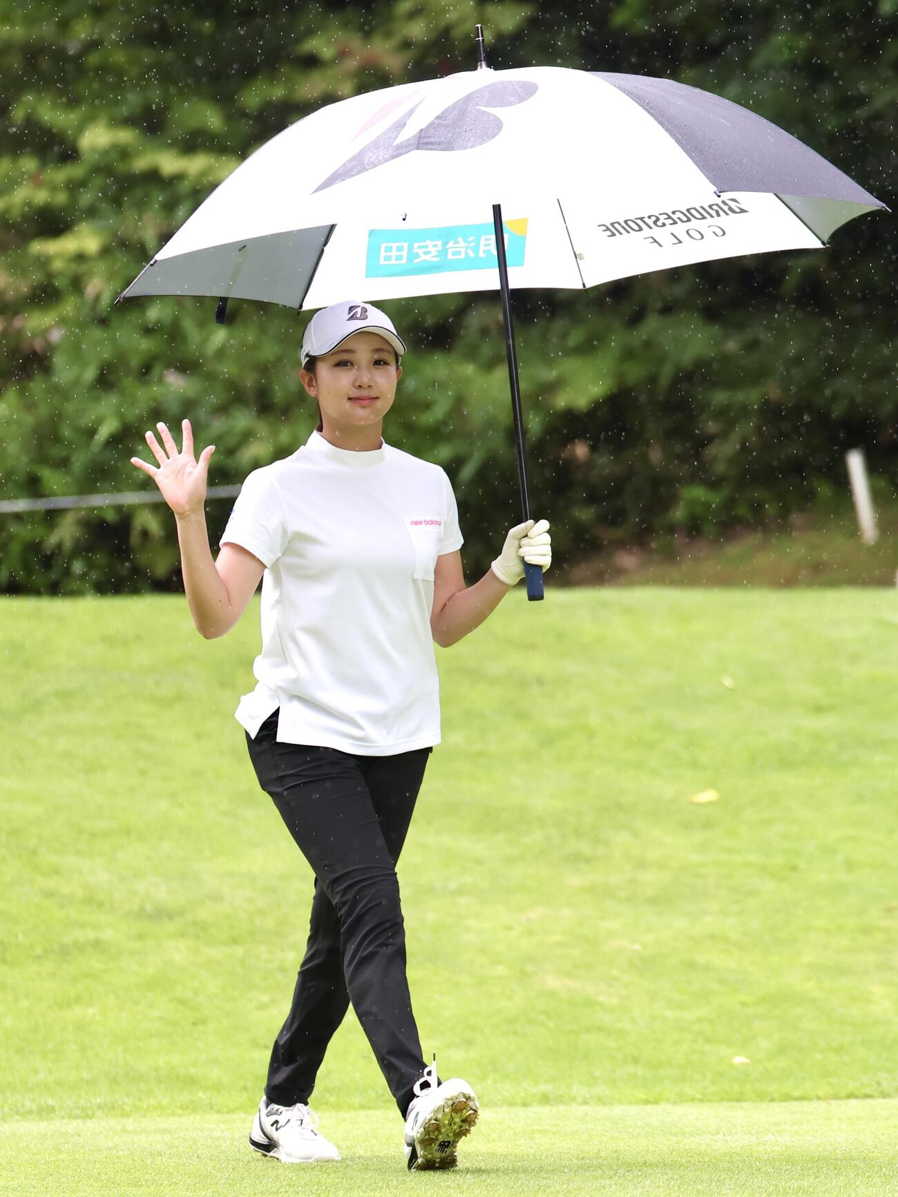 雨が降る中、傘を差して手を振る伊藤愛華（撮影・宮地輝）