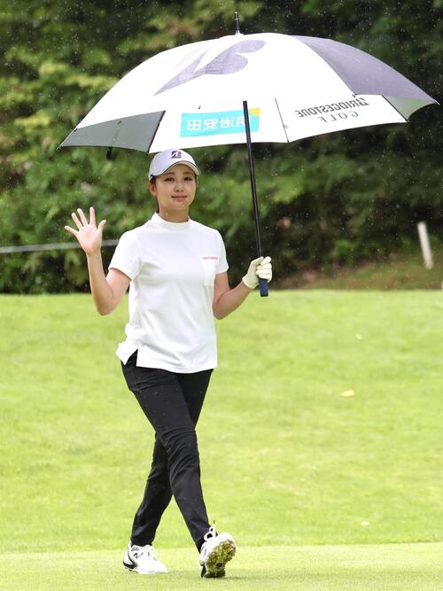 雨が降る中、傘を差して手を振る伊藤愛華（撮影・宮地輝）