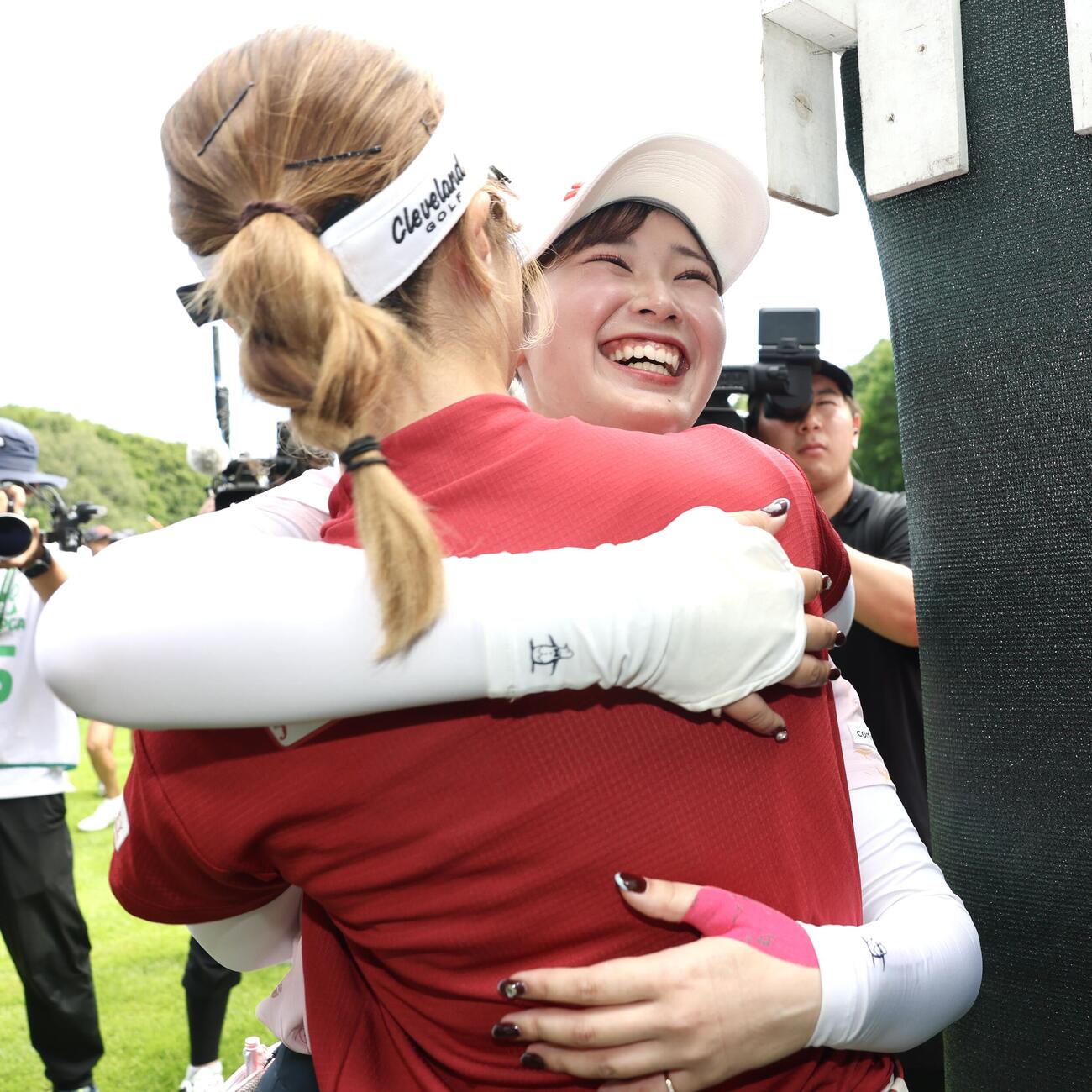 ツアー初優勝を決め都玲華（手前）と笑顔でハグする吉沢柚月（撮影・宮地輝）