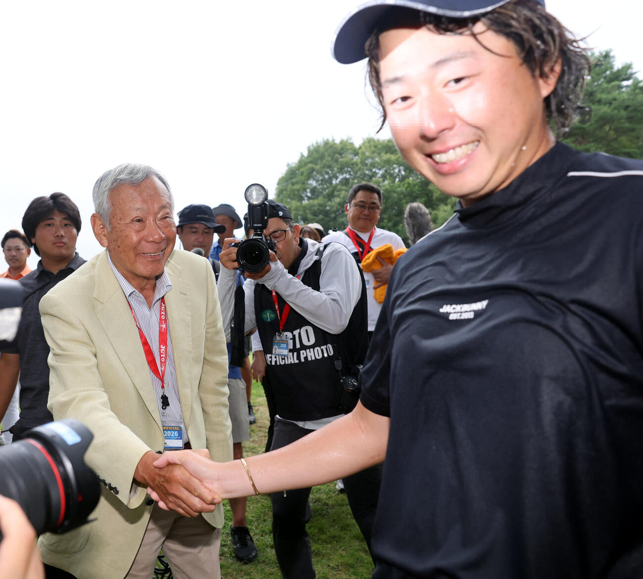 最終日　初優勝を決めた平本世中（右）は諸星裕日本ゴルフツアー機構会長と握手（撮影・浅見桂子）