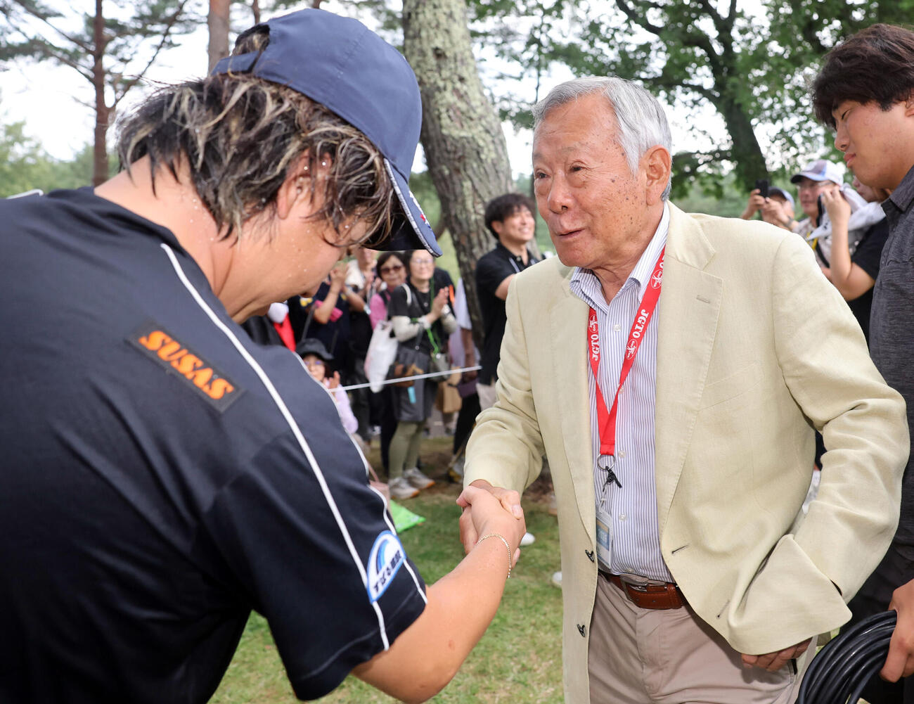 最終日　初優勝を決めた平本世中（左）は諸星裕日本ゴルフツアー機構会長と握手（撮影・浅見桂子）